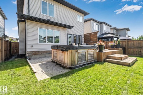 Expansive backyard featuring a wood-finish hot tub, multi-level wood-finish deck, and a manicured lawn - 1337 Secord Landing Nw, Edmonton, AB - Outdoor With Deck Patio Veranda With Exterior