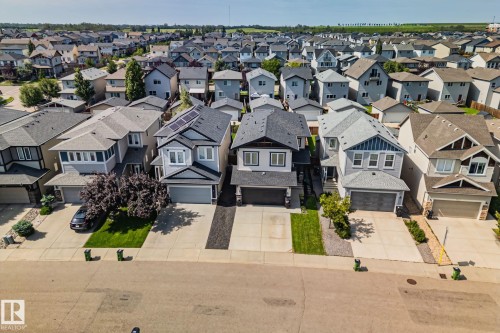 Residential neighborhood featuring detached homes with attached garages, paved driveways, and landscaped front yards - 1337 Secord Landing Nw, Edmonton, AB - Outdoor With Facade