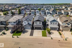 Residential neighborhood featuring detached homes with attached garages, paved driveways, and landscaped front yards - 