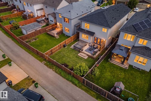 Expansive fenced backyard featuring a wood deck, manicured lawn, and a hot tub - 1337 Secord Landing Nw, Edmonton, AB - Outdoor