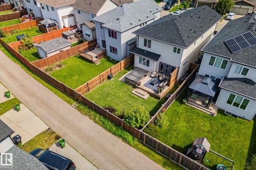 Fenced backyard with a wood deck, manicured lawn, and a storage shed - 1337 Secord Landing Nw, Edmonton, AB - Outdoor