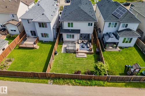 Rear exterior featuring a stone patio, built-in hot tub, and wood deck - 1337 Secord Landing Nw, Edmonton, AB - Outdoor