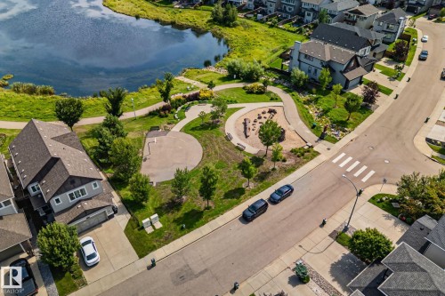 Lakeside community with paved walking paths, established green spaces, and a dedicated play area - 1337 Secord Landing Nw, Edmonton, AB - Outdoor With Body Of Water With View