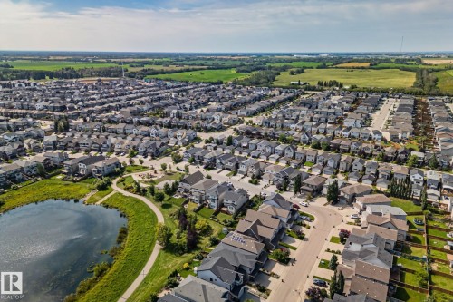 Residential community with a large central pond, curvilinear pathways, and adjacent green spaces - 1337 Secord Landing Nw, Edmonton, AB - Outdoor With View
