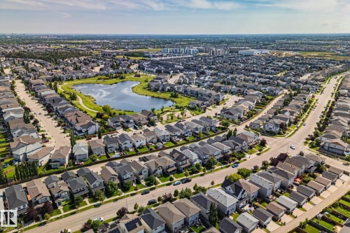 Expansive residential neighborhood featuring numerous detached properties, winding streets, and a central pond with surrounding green space - 1337 Secord Landing Nw, Edmonton, AB - Outdoor With View