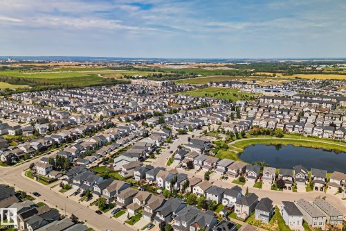 Residential neighborhood featuring a central pond, surrounding green space, and varied home styles - 1337 Secord Landing Nw, Edmonton, AB - Outdoor With Body Of Water With View