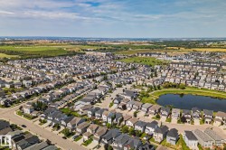 Residential neighborhood featuring a central pond, surrounding green space, and varied home styles - 