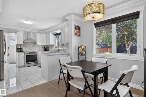 Open-concept kitchen with white cabinetry, tile backsplash, and stainless steel appliances - 8632 184 Street Nw, Edmonton, AB - Indoor