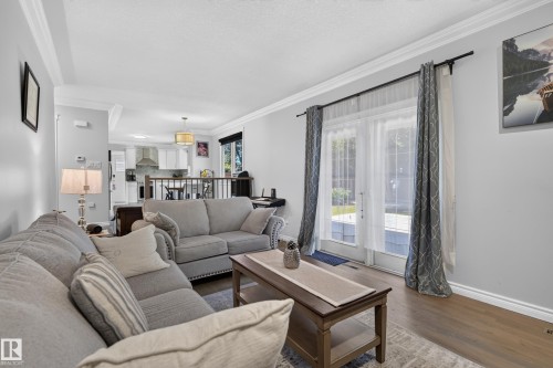 Wood-finish flooring, white crown molding, and light gray wall paint - 8632 184 Street Nw, Edmonton, AB - Indoor Photo Showing Living Room