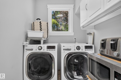 White shaker-style cabinetry, a white framed window, and a light gray wall finish - 8632 184 Street Nw, Edmonton, AB - Indoor Photo Showing Laundry Room