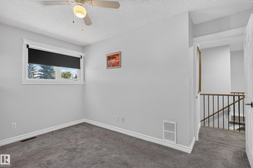 Recessed window with roller shade, ceiling fan with integrated lighting, carpeted flooring, and white trim - 8632 184 Street Nw, Edmonton, AB - Indoor Photo Showing Other Room