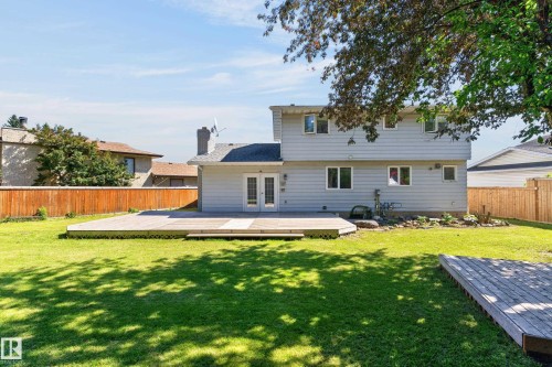 Expansive grassy yard featuring a large deck, additional wood platform, and wood privacy fencing - 8632 184 Street Nw, Edmonton, AB - Outdoor