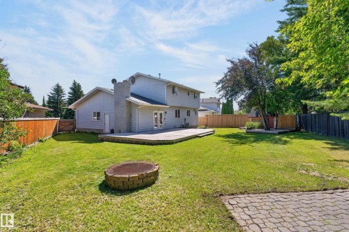 Spacious two-story residence with siding exterior and attached garage, set on a generous lot featuring mature landscaping, manicured lawn, and paver patio hardscaping - 8632 184 Street Nw, Edmonton, AB - Outdoor With Backyard