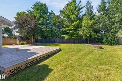 Expansive backyard featuring a natural wood deck, manicured lawn, and perimeter fencing - 8632 184 Street Nw, Edmonton, AB - Outdoor