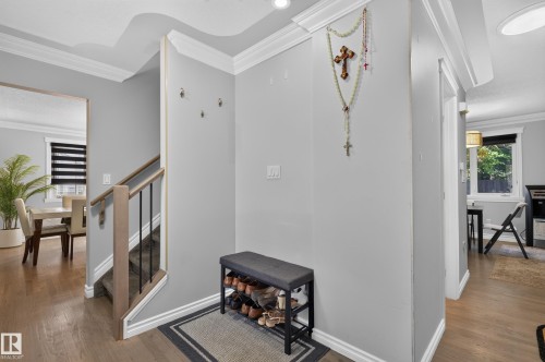 Hardwood-finish flooring, staircase with wood railing and black spindles, crown molding, recessed lighting, and a defined entryway - 8632 184 Street Nw, Edmonton, AB - Indoor Photo Showing Other Room