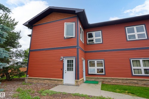 Entryway showing the red vinyl siding and low stone trim - 203 Graybriar Green, Stony Plain, AB - Outdoor With Exterior