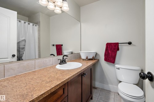 Vanity with a single basin sink, matte black faucet, and wood-finish cabinetry - 203 Graybriar Green, Stony Plain, AB - Indoor Photo Showing Bathroom