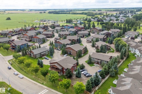 Residential community with varied architectural styles and mature landscaping, surrounded by open fields - 203 Graybriar Green, Stony Plain, AB - Outdoor With View