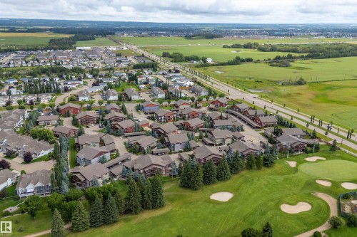 Residential area with varied architectural styles, bordered by mature trees and a golf course - 203 Graybriar Green, Stony Plain, AB - Outdoor With View