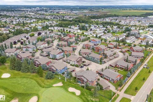 Residential development bordering a golf course, featuring multiple buildings with individual carports and surrounding green spaces - 203 Graybriar Green, Stony Plain, AB - Outdoor With View