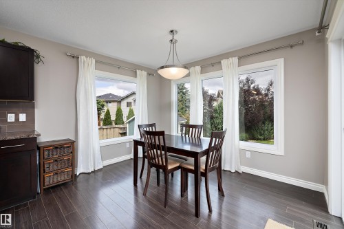 Wood-finish flooring with baseboard molding, dark wood cabinetry, and a countertop - 3922 Agar Court Sw, Edmonton, AB - Indoor Photo Showing Dining Room