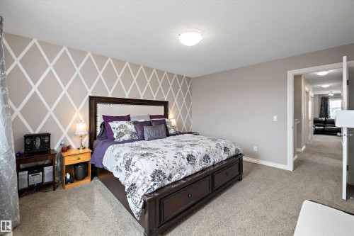 Textured wall accent, neutral wall paint, ceiling-mounted light fixture, carpeting, white trim - 3922 Agar Court Sw, Edmonton, AB - Indoor Photo Showing Bedroom