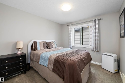 Textured carpeting, light neutral wall paint, white trim, and a window with horizontal blinds - 3922 Agar Court Sw, Edmonton, AB - Indoor Photo Showing Bedroom