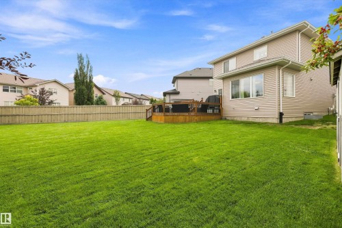 Expansive backyard featuring a large grassy area, privacy fencing, and a multi-level wood deck - 3922 Agar Court Sw, Edmonton, AB - Outdoor