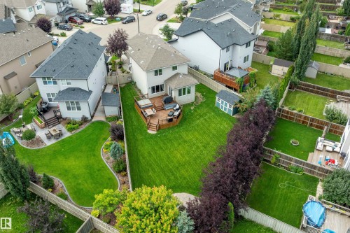 Expansive backyard featuring a manicured lawn, multi-level wood deck, and mature privacy trees - 3922 Agar Court Sw, Edmonton, AB - Outdoor With View