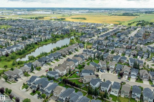 Residential area featuring a central pond, established roadways, and green spaces - 3922 Agar Court Sw, Edmonton, AB - Outdoor With View