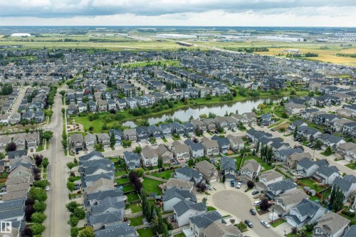 Established residential community featuring a prominent central pond, extensive green spaces, and mature tree-lined streets - 3922 Agar Court Sw, Edmonton, AB - Outdoor With View