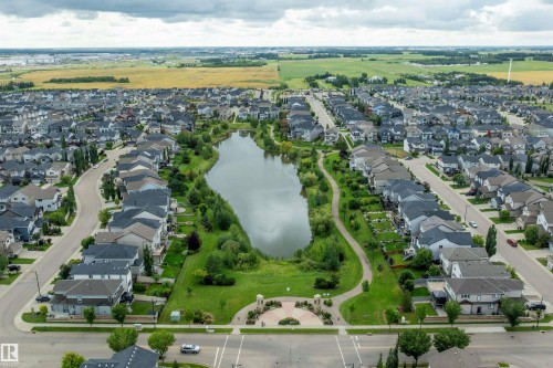 Residential neighborhood featuring a central pond, manicured green spaces, paved walking paths, and a variety of detached homes - 3922 Agar Court Sw, Edmonton, AB - Outdoor With View