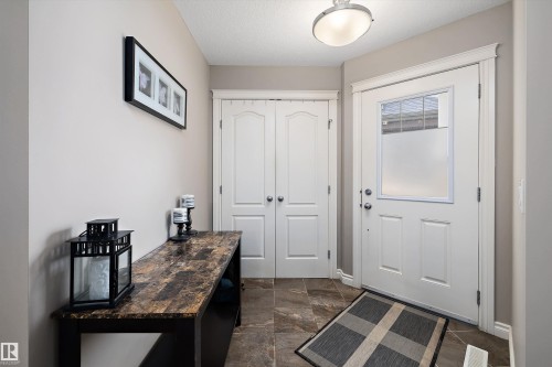 Entryway featuring white paneled doors, a frosted glass insert front door, and dark-toned floor tiles - 3922 Agar Court Sw, Edmonton, AB - Indoor Photo Showing Other Room