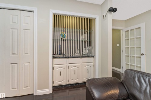 Built-in wet bar featuring a sink, base cabinetry, and glass shelving - 6016 177 Street Nw, Edmonton, AB - Indoor Photo Showing Other Room