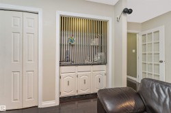 Built-in wet bar featuring a sink, base cabinetry, and glass shelving - 