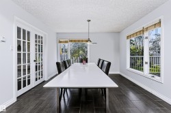 Spacious room featuring dark wood-finish flooring, white trim, and a white ceiling - 