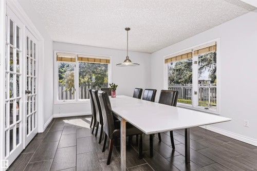 White interior walls with dark wood-finish tile flooring - 6016 177 Street Nw, Edmonton, AB - Indoor Photo Showing Dining Room