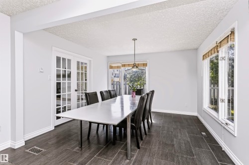 French doors with glass panes, transom windows, pendant lighting, and tile flooring - 6016 177 Street Nw, Edmonton, AB - Indoor Photo Showing Dining Room