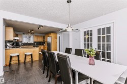 Open concept kitchen featuring wood-finish cabinetry, stainless steel appliances, and a breakfast bar - 