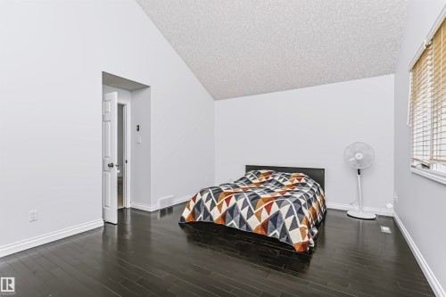 Vaulted ceiling, dark wood-finish flooring, white walls, white trim, and a window with blinds - 6016 177 Street Nw, Edmonton, AB - Indoor Photo Showing Bedroom