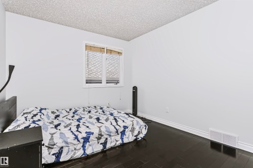 Hardwood-style flooring with a window featuring horizontal blinds - 6016 177 Street Nw, Edmonton, AB - Indoor Photo Showing Bedroom