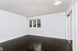 Dark wood-finish flooring, white trim, and a window with blinds - 