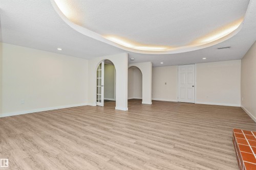 Spacious room featuring wood-finish flooring, recessed lighting, and a cove ceiling with accent lighting - 6016 177 Street Nw, Edmonton, AB - Indoor Photo Showing Other Room