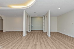 Wood-finish flooring throughout, recessed lighting, arched doorways, and double French doors - 