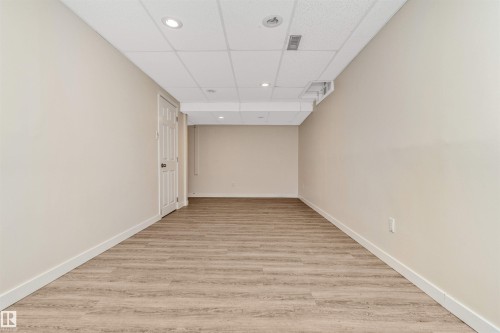 Neutral wall tones, wood-finish flooring, recessed lighting, and a drop ceiling - 6016 177 Street Nw, Edmonton, AB - Indoor Photo Showing Other Room