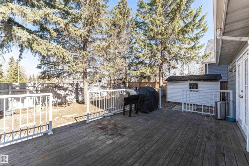 Spacious wood deck with white railings and French doors opening to the exterior - 6016 177 Street Nw, Edmonton, AB - Outdoor With Exterior
