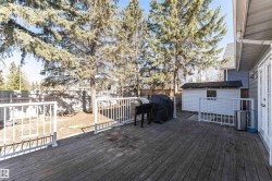 Spacious wood deck with white railings and French doors opening to the exterior - 