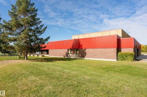 Brick and red corrugated metal exterior with multiple windows - 6016 177 Street Nw, Edmonton, AB - Outdoor