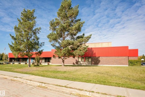 Brown brick exterior with red metal siding accents - 6016 177 Street Nw, Edmonton, AB - Outdoor