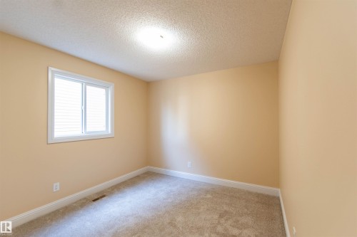 Carpeted flooring, neutral wall color, white trim, window with blinds, ceiling-mounted light fixture - 1419 Chahley Place Nw, Edmonton, AB - Indoor Photo Showing Other Room